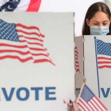 Woman voting in a face mask at the polls