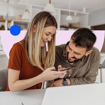 A couple happily looking at a phone screen, both smiling