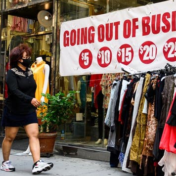 A woman walks by a store going out of business in New York City.
