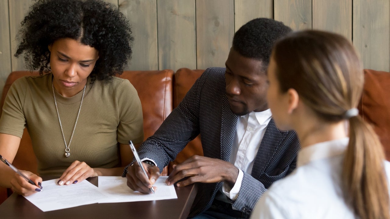 A couple signs mortgage documents
