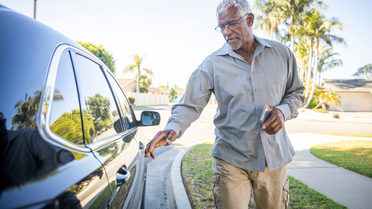 A man gets into a car.