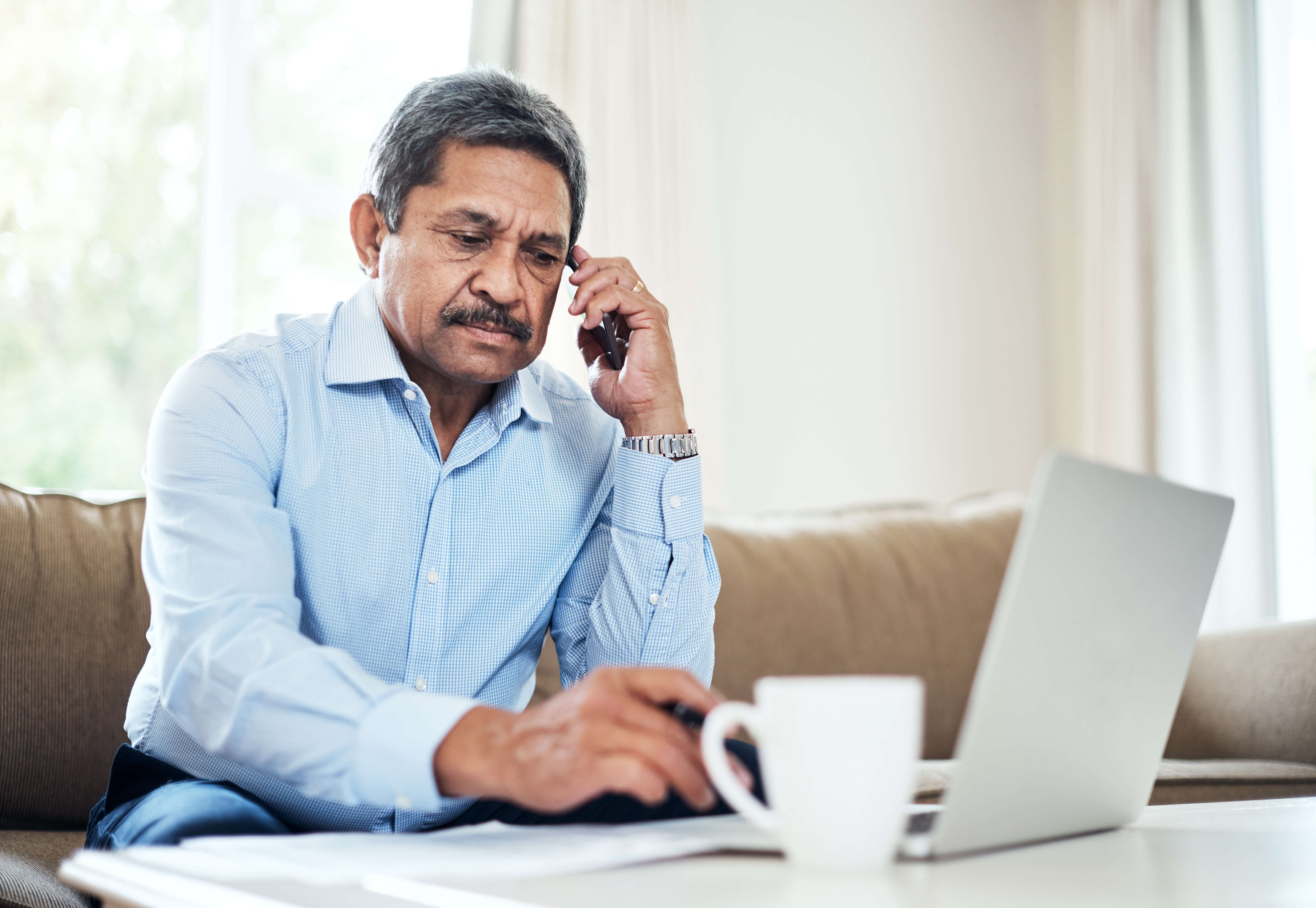 stock image showing a man on the phone at his computer