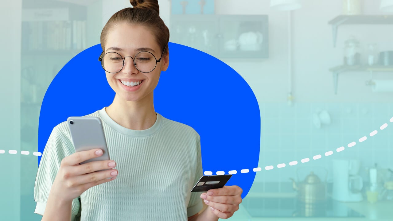 Person looking at phone and holding credit card