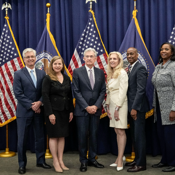 Members of the Federal Reserve Board of Governors stand with Fed Chair Jerome Powell after he was sworn in for his second term.