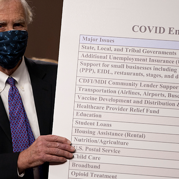 Sen. Angus King (I-ME) sets up a sign alongside a bipartisan group of Democrat and Republican members of Congress as they announce a proposal for a Covid-19 relief bill.