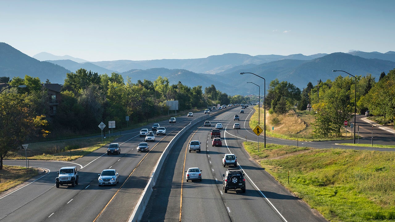 Rocky Mountains rise above late afternoon traffic, just outside of Boulder, Colorado, on Highway 36, also known as the Boulder Turnpike. The highway runs east to west and is the major route into downtown Boulder, Colorado.