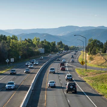 Rocky Mountains rise above late afternoon traffic, just outside of Boulder, Colorado, on Highway 36, also known as the Boulder Turnpike. The highway runs east to west and is the major route into downtown Boulder, Colorado.