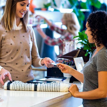 women handing over credit card at counter store