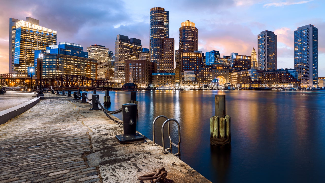 View of the Boston skyline at night from the coast of the harbor.