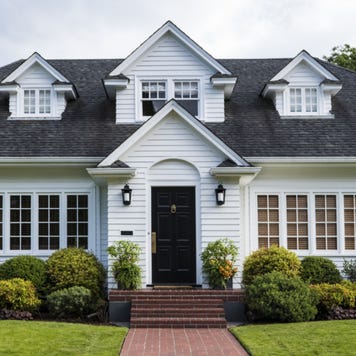 The exterior of a single-family home with dormers and yard