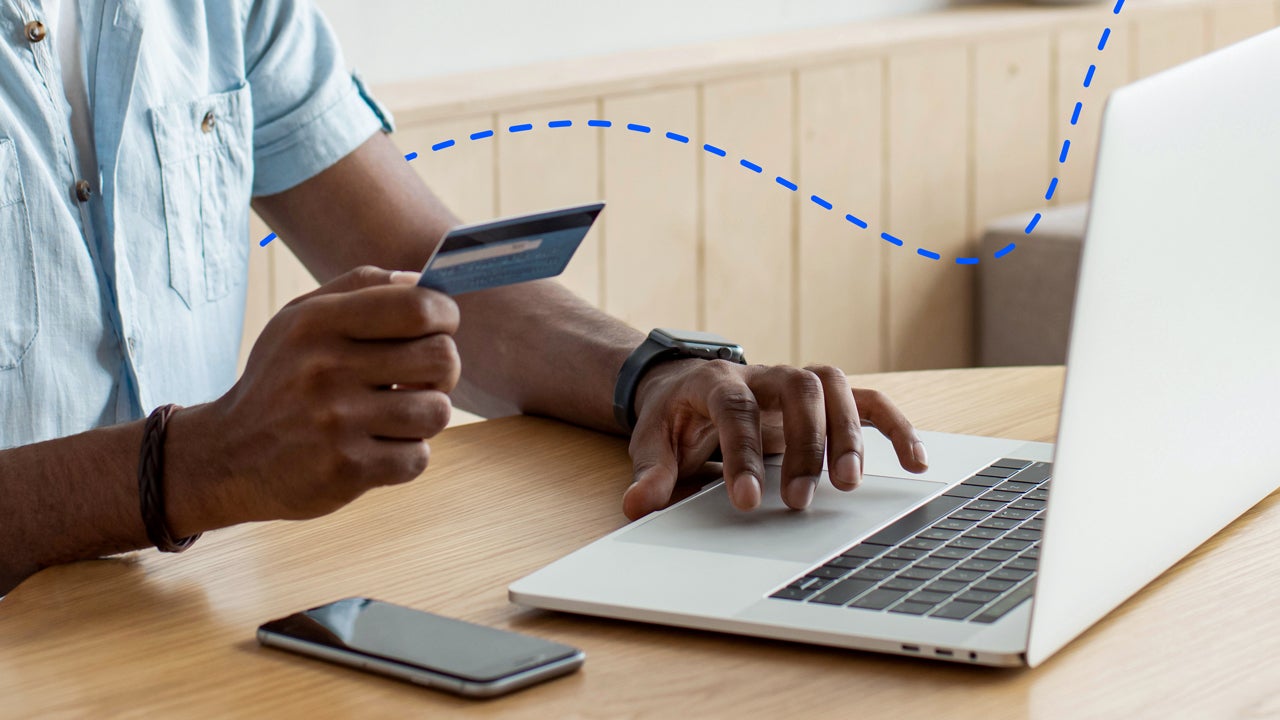 adult on his computer paying with a card