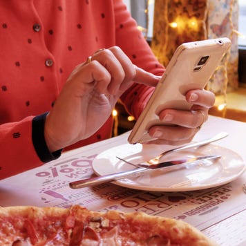 A woman uses mobile banking while eating.