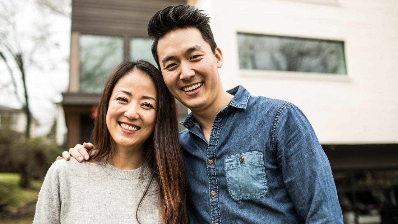 Portrait of young couple in front of new home