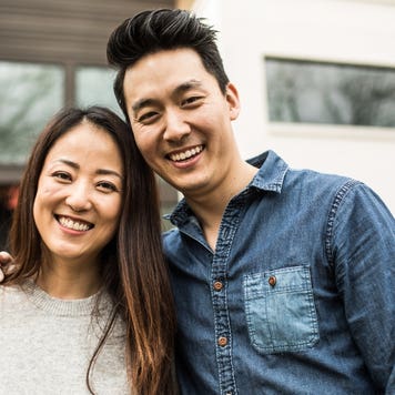 Portrait of young couple in front of new home