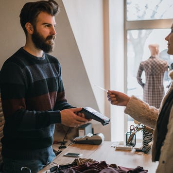 Woman using credit card to pay at small business