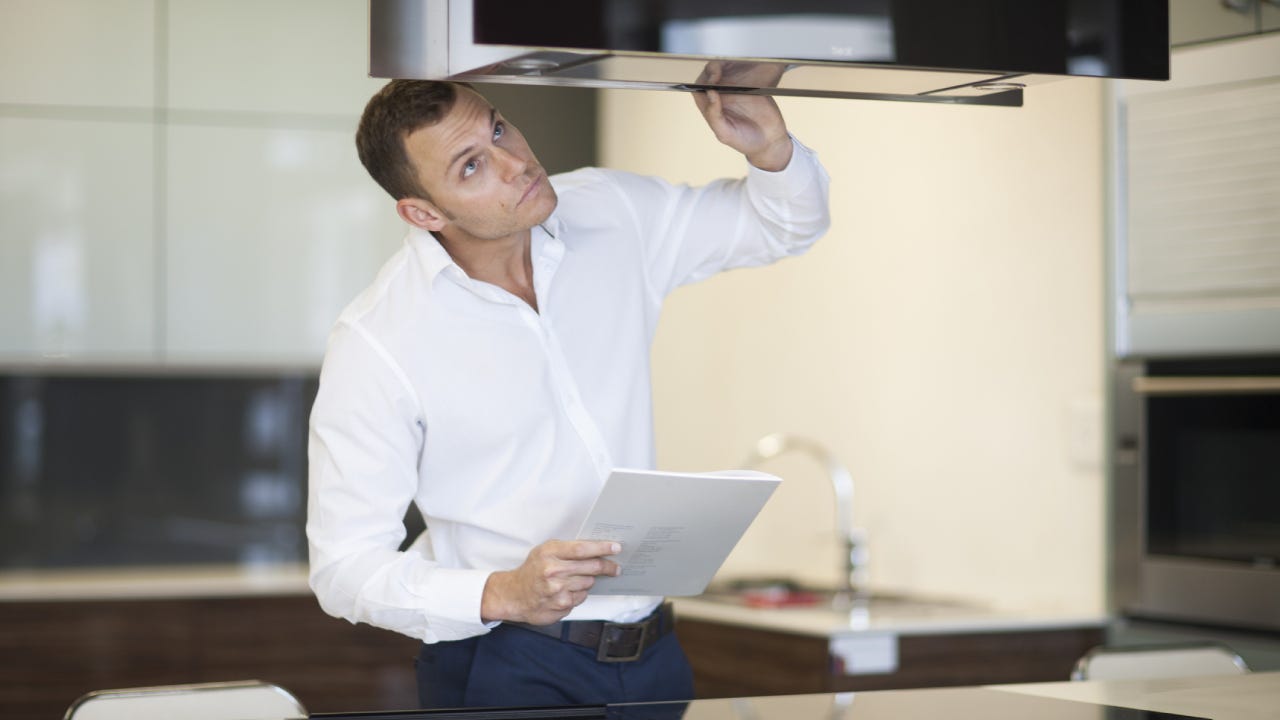 Mid adult man inspecting extractor hood in kitchen showroom