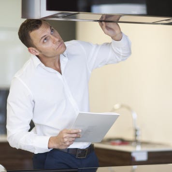 Mid adult man inspecting extractor hood in kitchen showroom