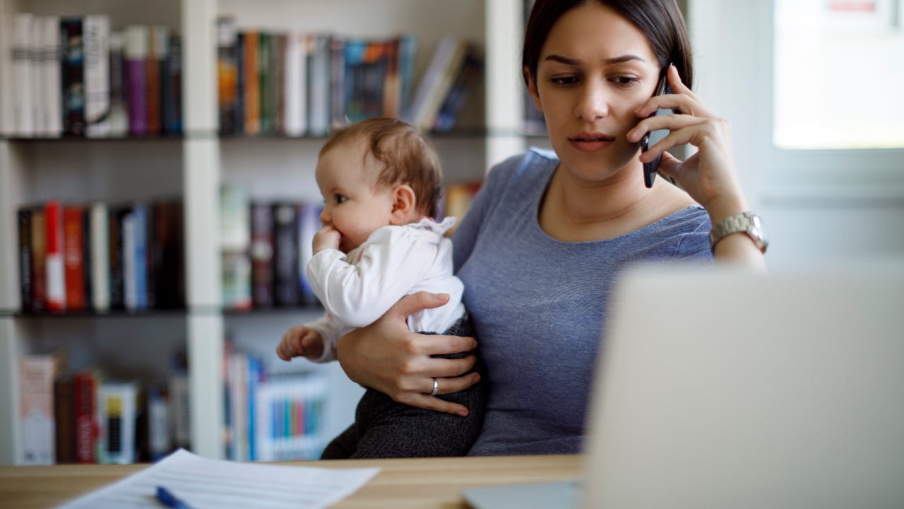 Worried mother holds baby while on the phone