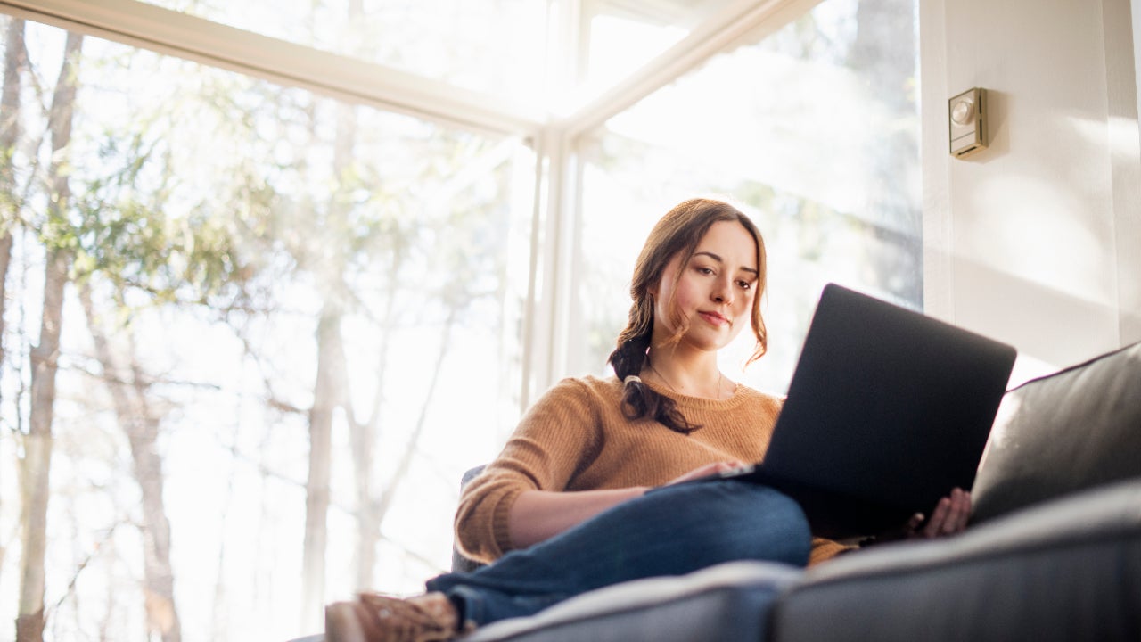 Woman sitting on a sofa looking at her laptop