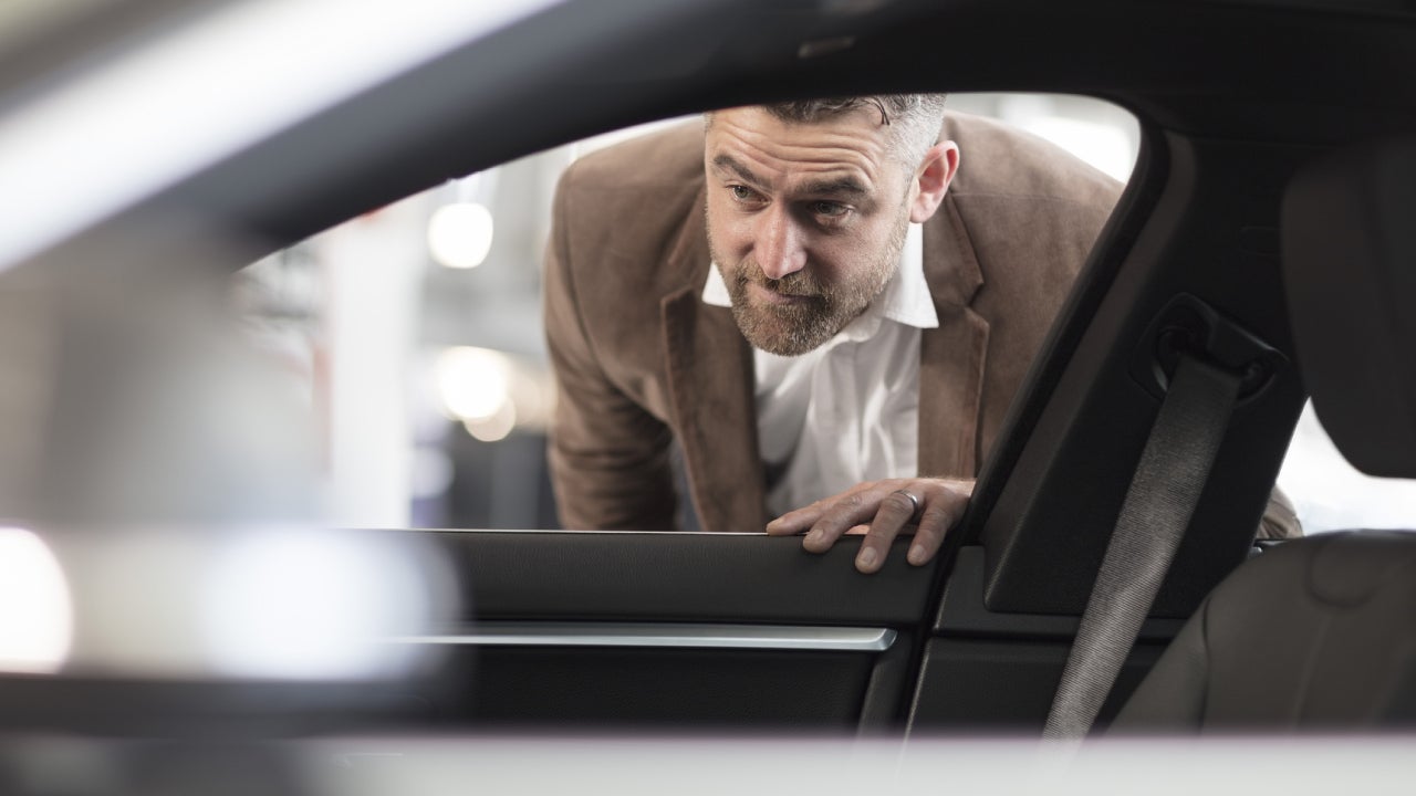 Man looking into car in car dealership