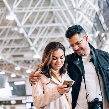 Couple at airport looking at smartphone