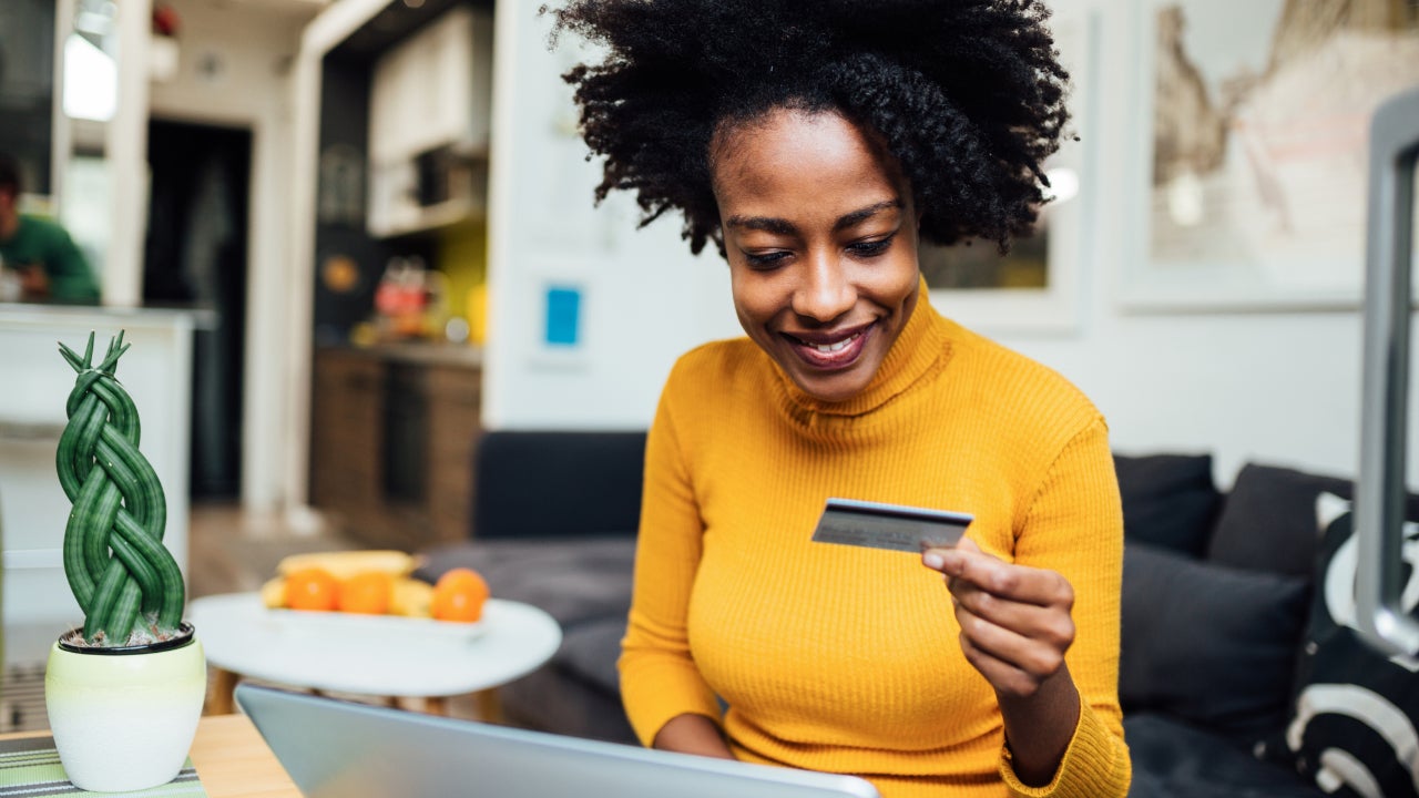 Woman holding credit card with laptop