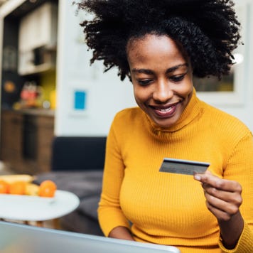 Woman holding credit card with laptop