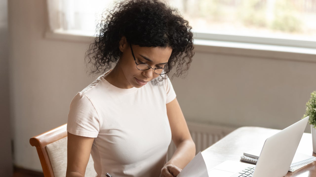 Concentrated young african american business woman signing documents