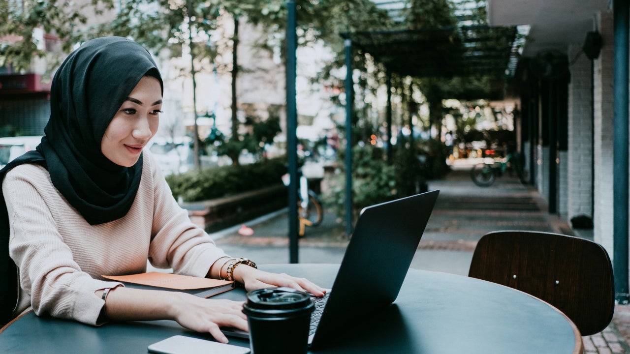 Young woman working at coffee shop on laptop