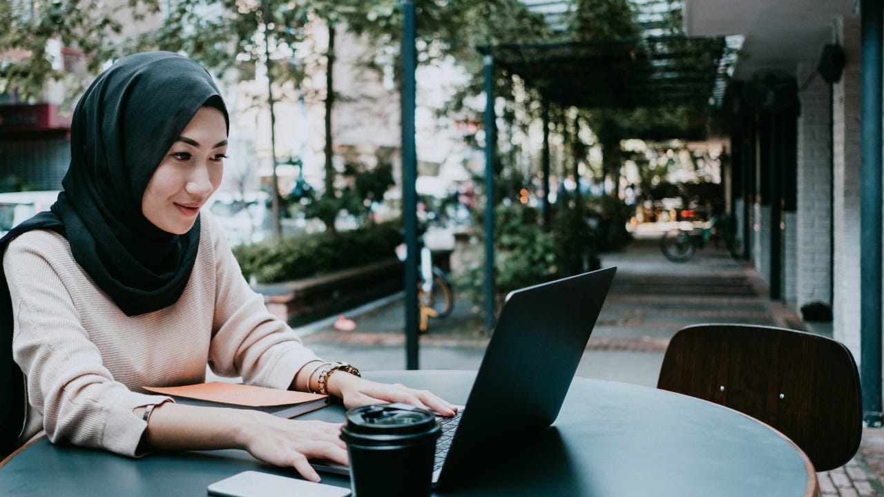 Young woman working at coffee shop on laptop