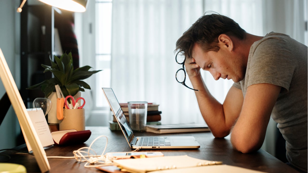 Stressed man looks at his laptop.