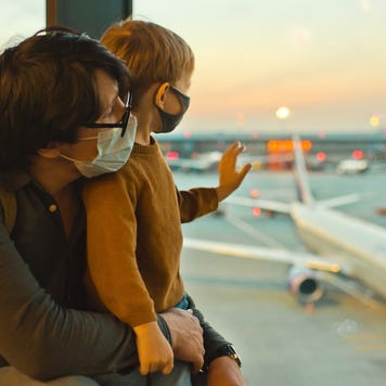 Father and son at airport wearing masks