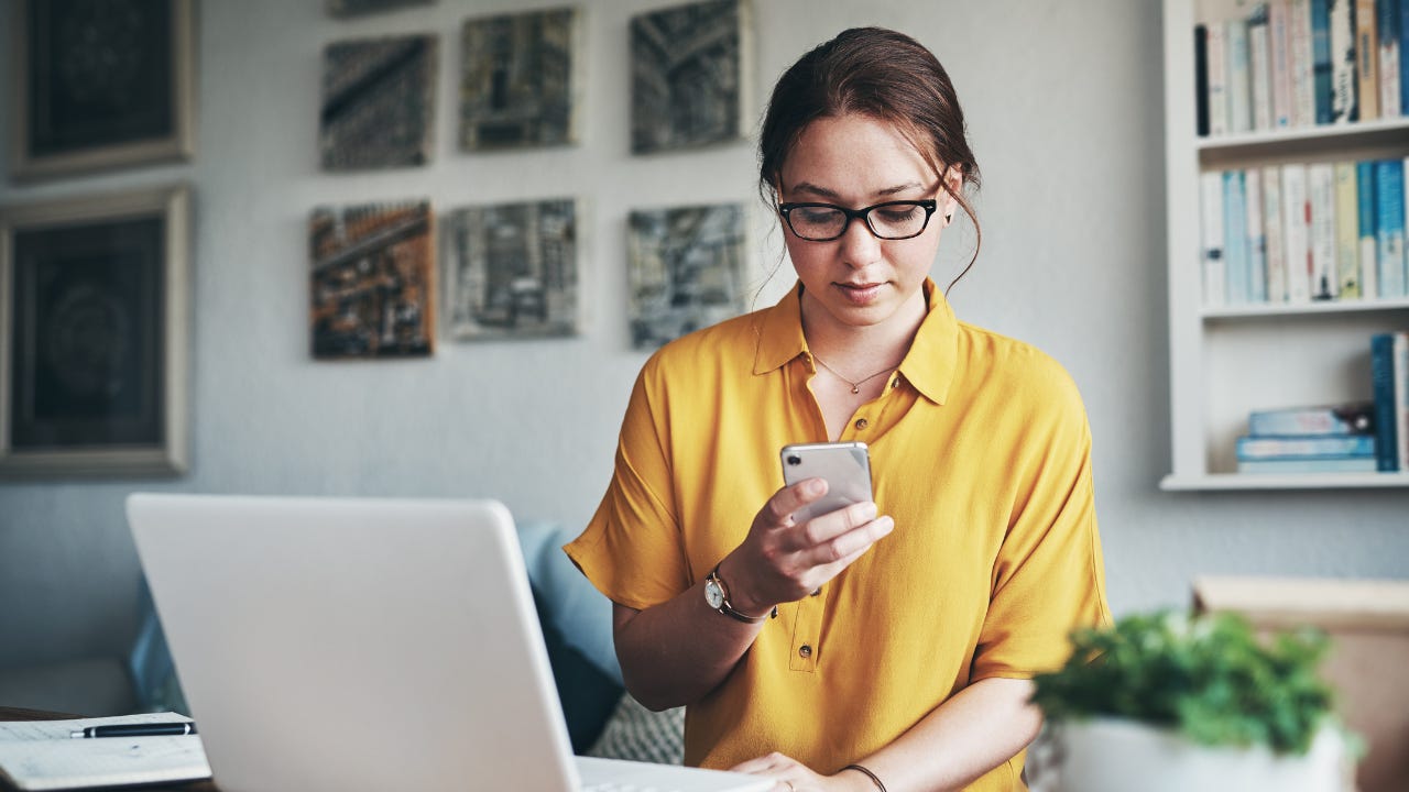 Woman on smartphone and laptop