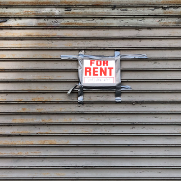 For Rent sign taped on gated storefront, Queens, New York