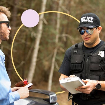 A police officer writing a driver a speeding ticket.