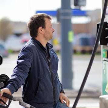 Middle-aged man pumps gas