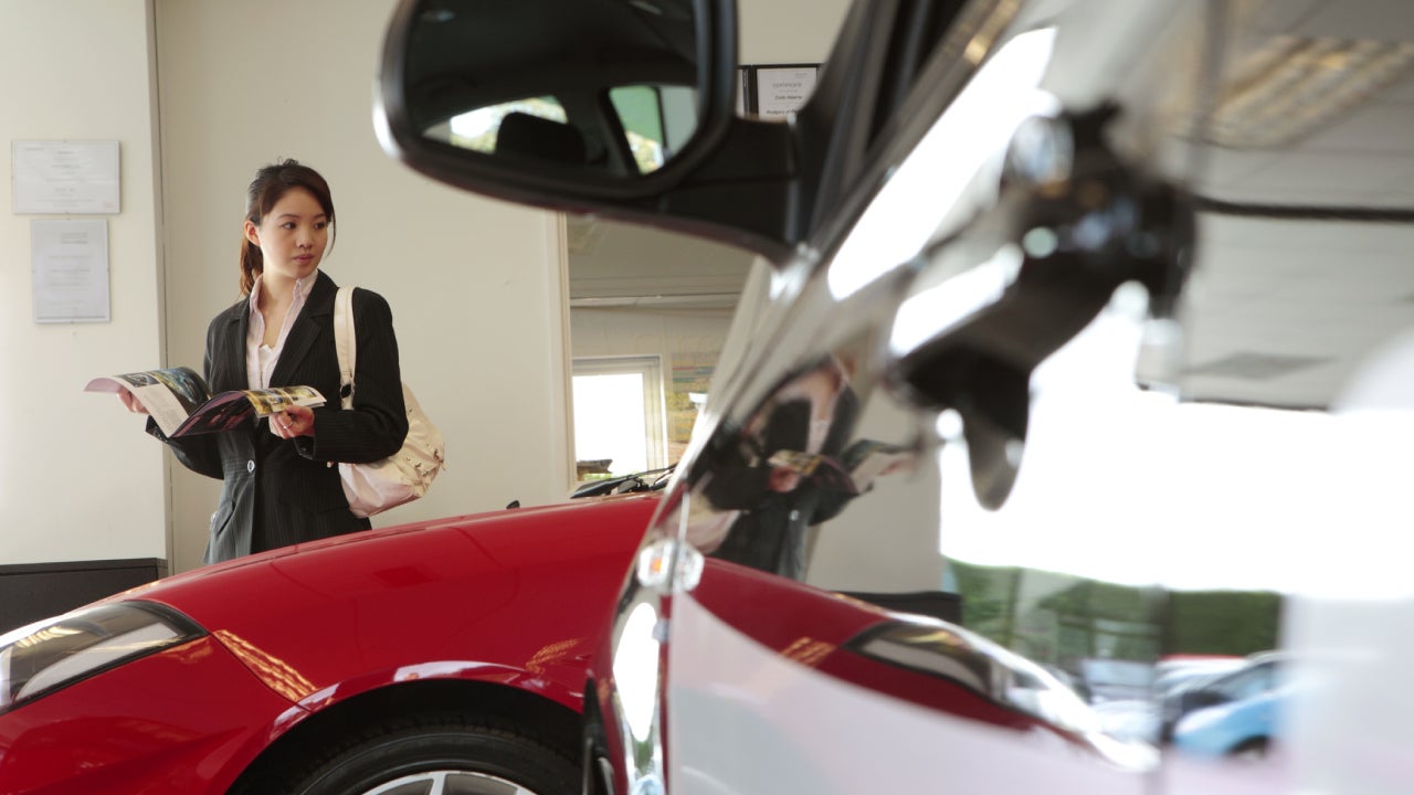 chinese female executive in car showroom