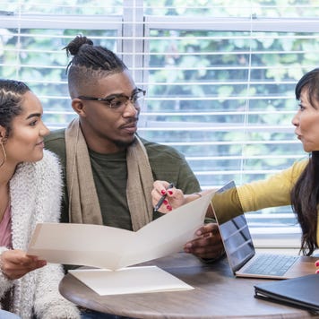 Young couple with advisor, signing paperwork