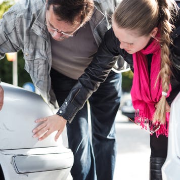 Man and woman looking car after accident.
