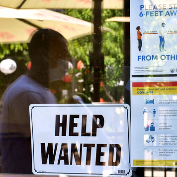 A 'Help Wanted' sign is posted beside Coronavirus safety guidelines in front of a restaurant.