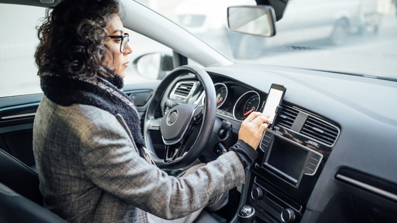 Woman uses navigation on her mobile phone in the car