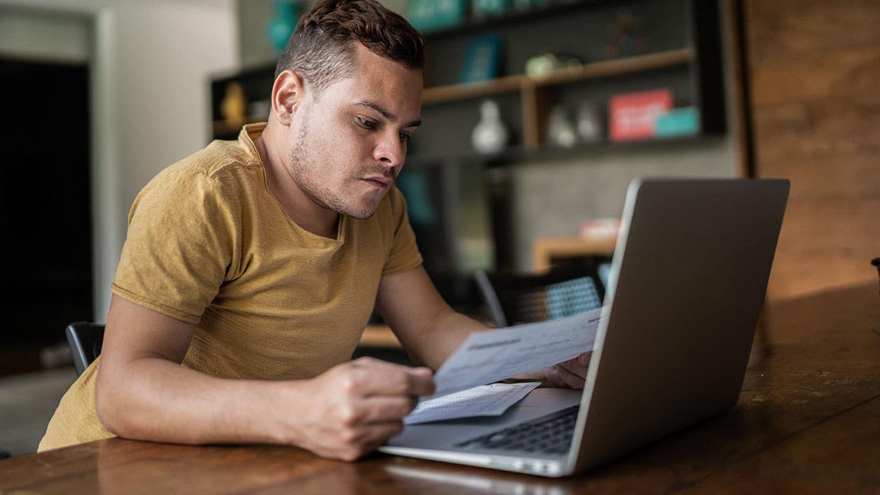 Young man with dwarfism doing home finances