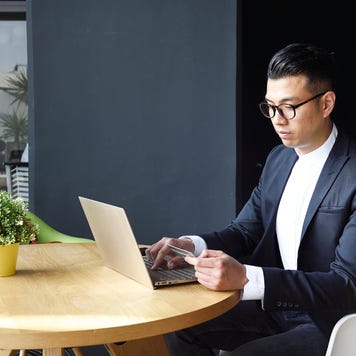Well dressed Asian man making an online purchase