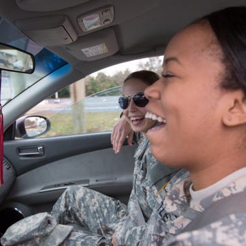 two women in military uniforms driving in a car