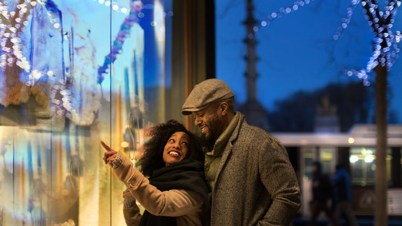 Couple window shopping in city at night