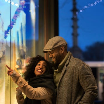 Couple window shopping in city at night