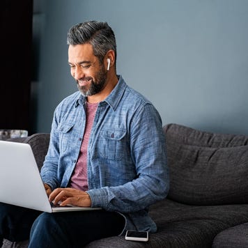 man typing on laptop while working from home