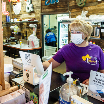 Cashier and customer wear face masks at a store during the pandemic