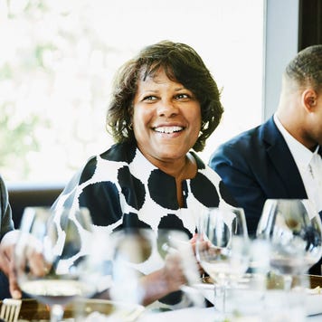 Smiling mature woman sharing a meal with family in restaurant