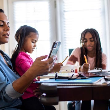 Mother working from home while daughters homeschool